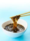 タレの具材として使用される、大分特産の「天然クロメ」を箸で持ち上げているアップ画像。クロメ特有の強い粘り気と、磯の風味を伝えるビジュアル。