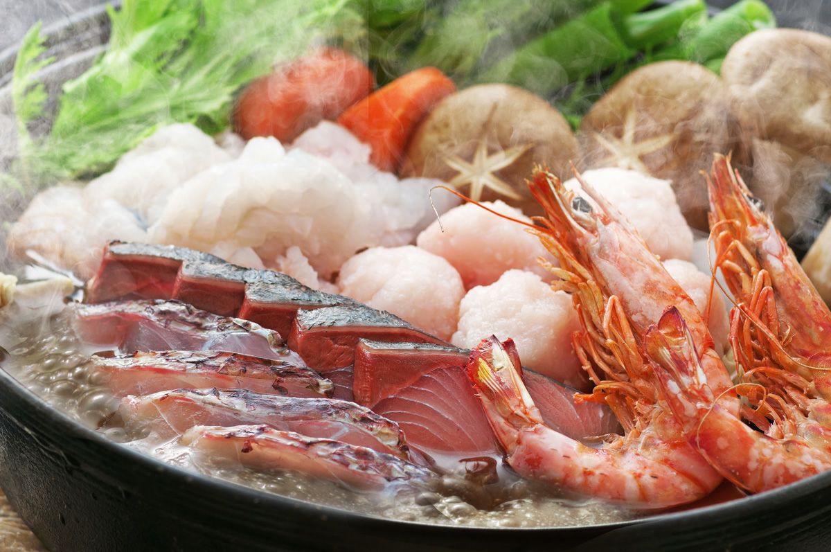 大分県産の新鮮な魚介がたっぷり入った「海鮮寄せ鍋セット」を鍋で煮込んでいる調理イメージ画像。魚介の出汁が効いた本格的な寄せ鍋を、ご自宅で手軽に楽しめます。