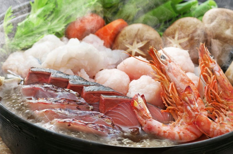 大分県産の新鮮な魚介がたっぷり入った「海鮮寄せ鍋セット」を鍋で煮込んでいる調理イメージ画像。魚介の出汁が効いた本格的な寄せ鍋を、ご自宅で手軽に楽しめます。