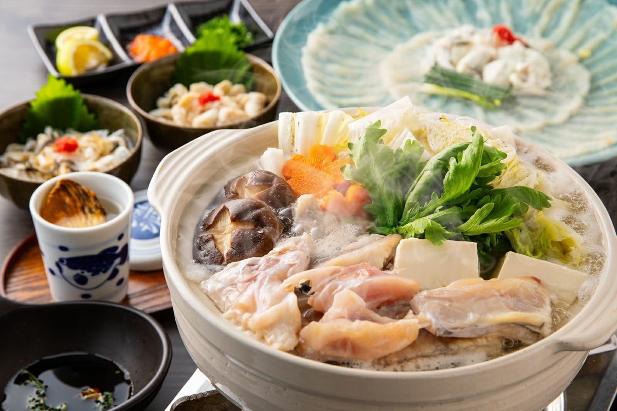 大分県産の高級魚「豊後とらふぐ」料理セットで楽しめる、てっさ（刺身）、てっちり（鍋）、ヒレ酒の豪華な食卓の盛り付け画像。ご贈答にも最適な大分のご当地ふぐセットを通販でお取り寄せ。