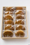 「昭和の町高田屋のどら焼き 12個入り」のギフト箱に、素材にこだわったどら焼きが詰められた内容量画像。贈答やお土産に最適な、自家製餡の和菓子セット。