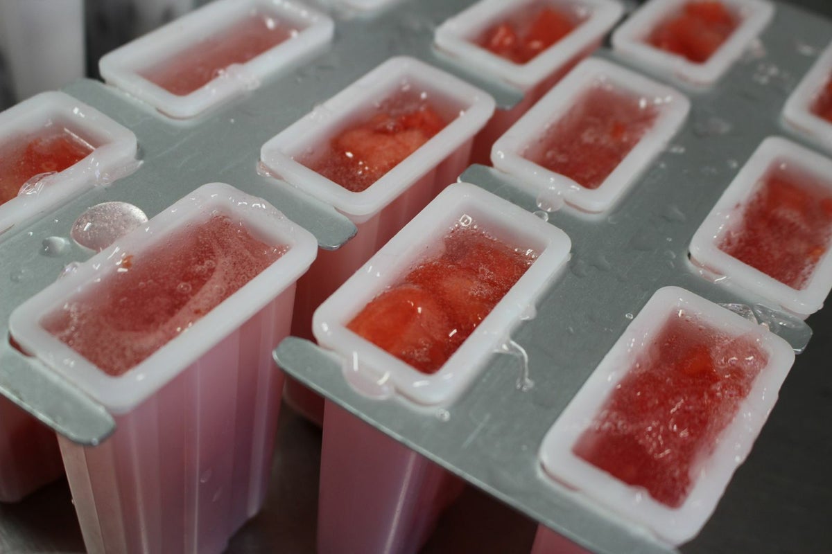 溶けないアイスキャンデーの生地を、アイスの型に流し込んでいる製造工程の画像。葛と果肉を混ぜた、もちシャリ食感を生み出す特別な工程。