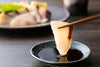 新鮮な関ぶりの刺身（関冷刺）を醤油につけているアップ画像。身の締まりと脂の乗りが伝わる、大分からのお取り寄せ海鮮。