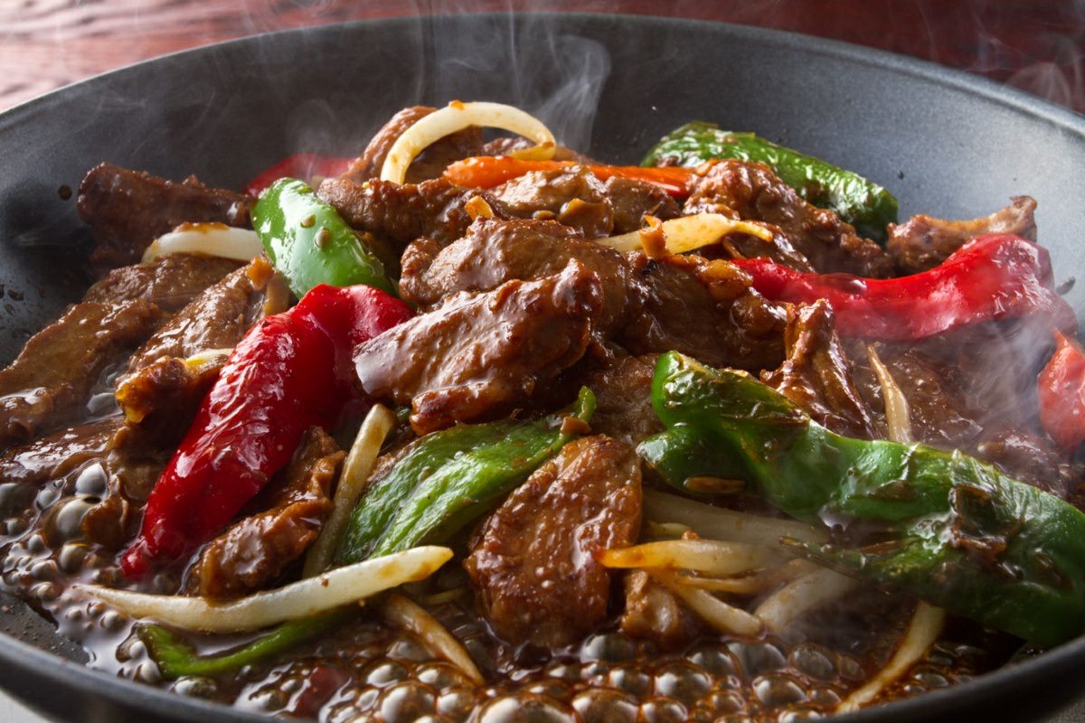 秘伝のタレに漬け込んだ福地のうなるホルモン「豚サガリ」を鉄板で焼いている調理中の画像。ホルモンでありながら柔らかくあっさりした脂で、ヘルシーに楽しめる。