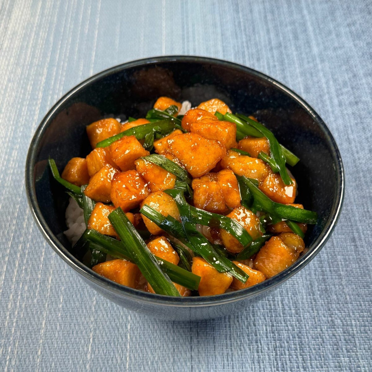 大分県の郷土料理「トリニータ丼」キットの調理例。鶏肉とニラを甘辛いタレで炒めてご飯に盛り付けた、スタミナ満点のご当地ソウルフード丼。