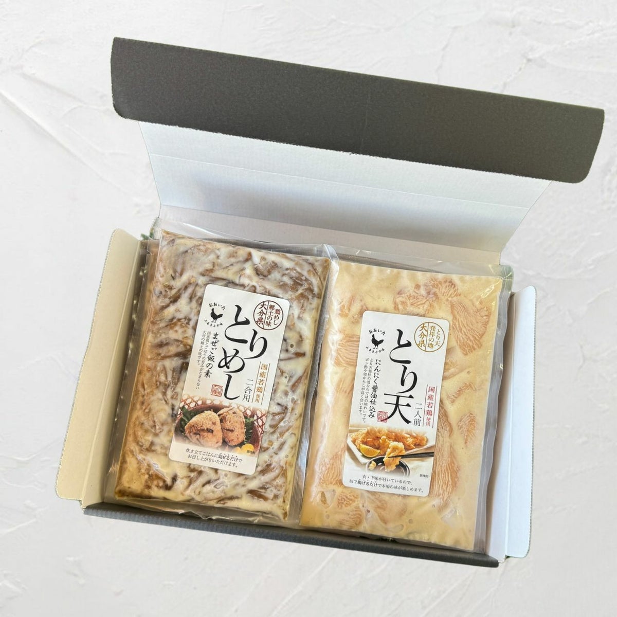 大分名物「とり天」と「鶏めし」のセットが、贈答用化粧箱に詰められた内容量画像。帰省土産やギフトにも最適な、大分の郷土食セット。