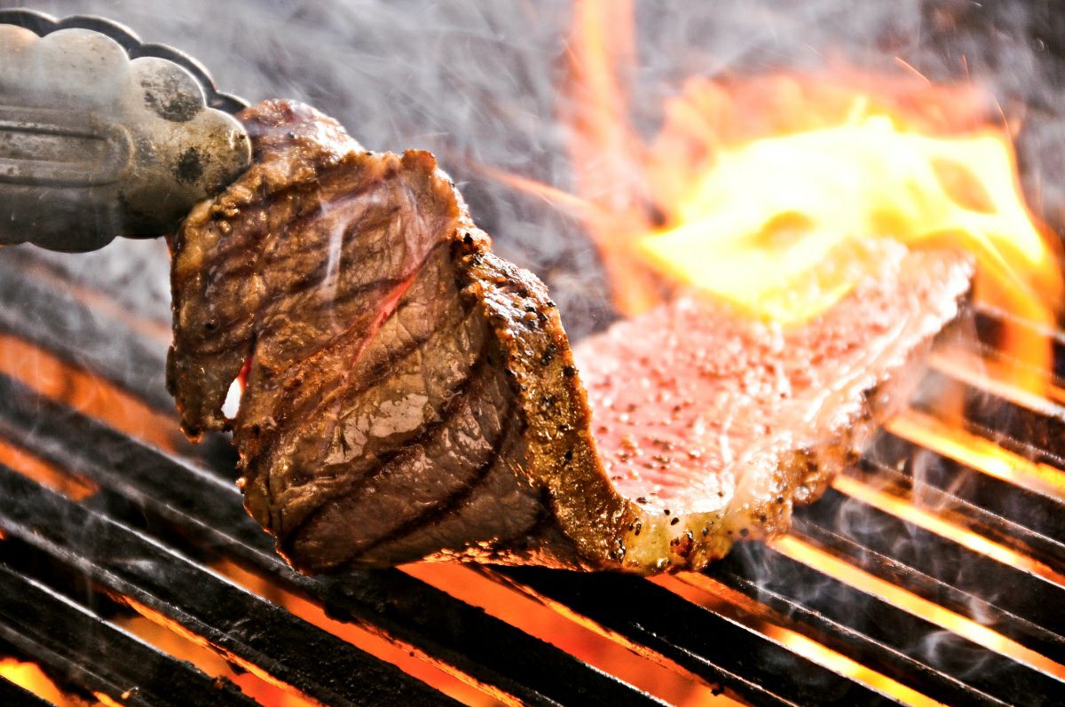 大分県産「おおいた和牛サーロインステーキ」を鉄板やグリルで焼いている調理中の画像。ジュージューと音を立てる、食欲をそそる高級和牛ステーキの調理風景。