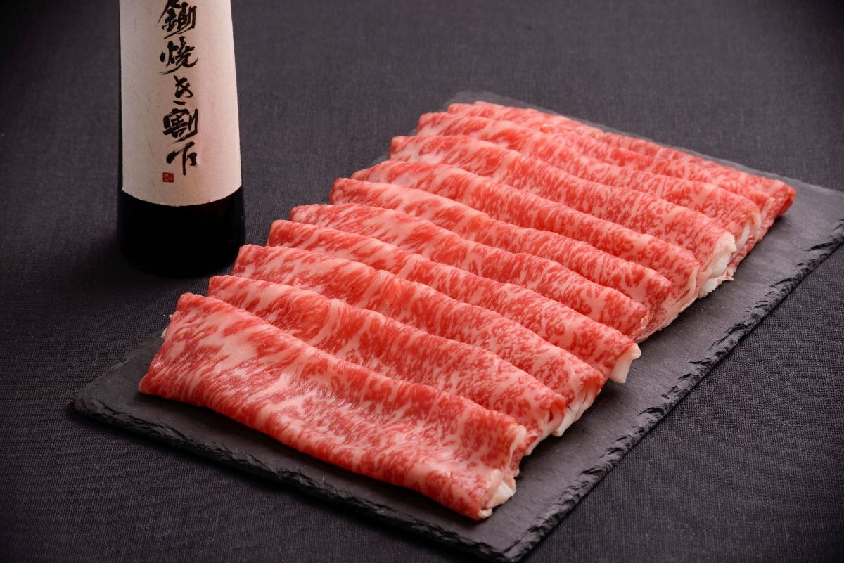 大分県のブランド牛「おおいた和牛」のすき焼き用スライス肉を皿に美しく盛り付けた画像。きめ細やかな霜降りと柔らかな肉質が特徴の高級和牛セット。