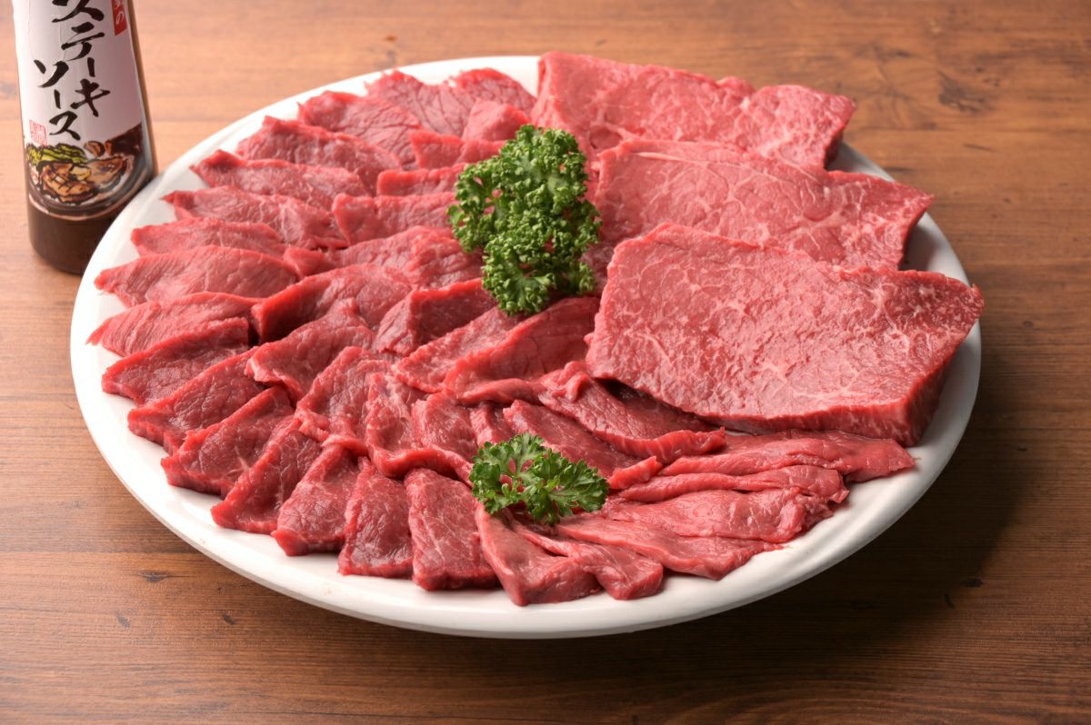 大分県のブランド牛「おおいた和牛」の赤身肉を皿に美しく盛り付けた調理前の画像。ヘルシー志向の方や、肉の旨味を堪能したい方に最適なステーキソース付きセット。