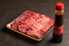 大分県のブランド牛「おおいた和牛」のカルビ焼き肉用スライス肉500gを皿にきれいに並べた内容量画像。霜降りが美しく、つけダレ300gもセットになった便利なセット。