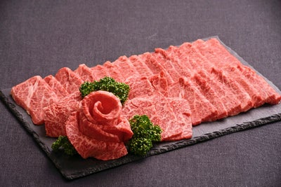 大分県のブランド牛「おおいた和牛」（カルビ、ロースなど）と、特製ダレで味付けされた「国産ホルモン」を大皿に盛り付けた調理前の画像。豪華な焼肉の食べ比べが楽しめるセット。