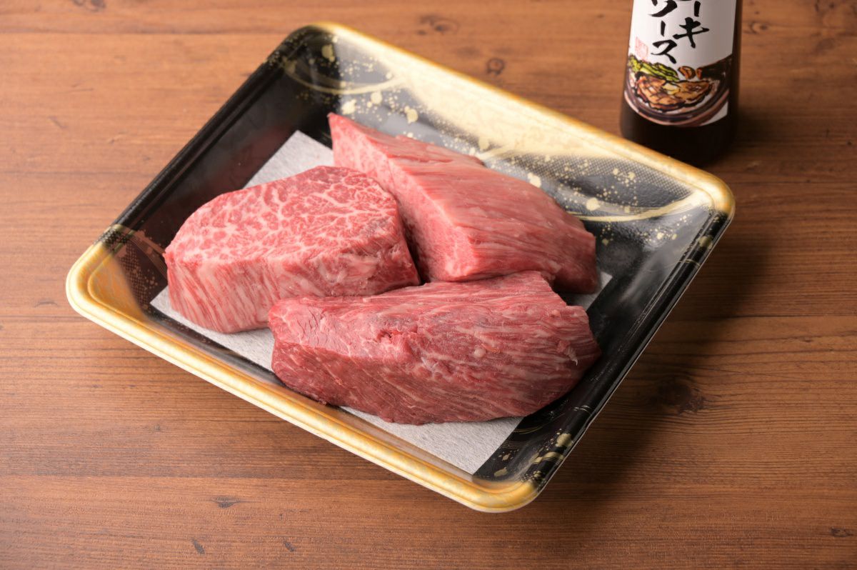 大分県産の「訳ありおおいた和牛ヒレステーキ肉」がパックに無造作に入り、ステーキソースと並べられた内容量画像。形は不揃いだが、お得にご自宅で楽しめるヒレ肉セット。