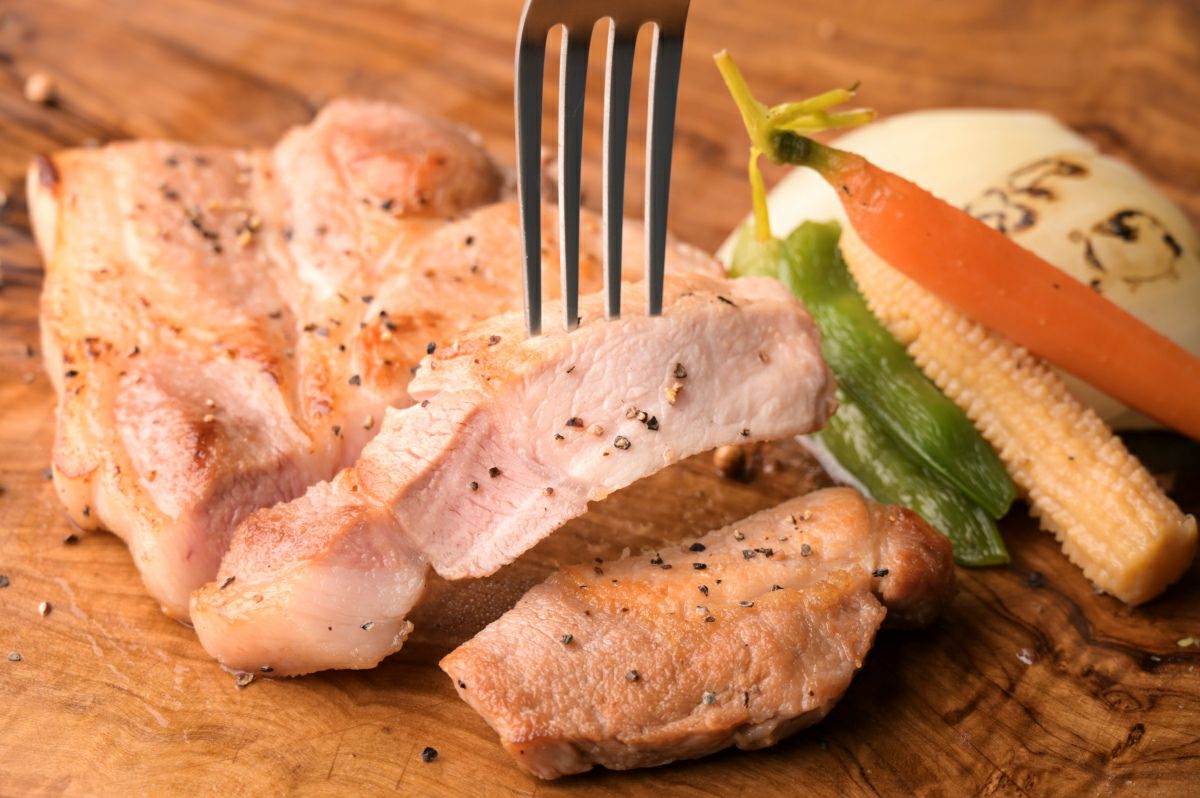 焼き上げた「奥豊後豚ステーキ」を一口サイズにカットし、皿に盛り付けた画像。厚切りでジューシーな豚肉のステーキを自宅で楽しめる。