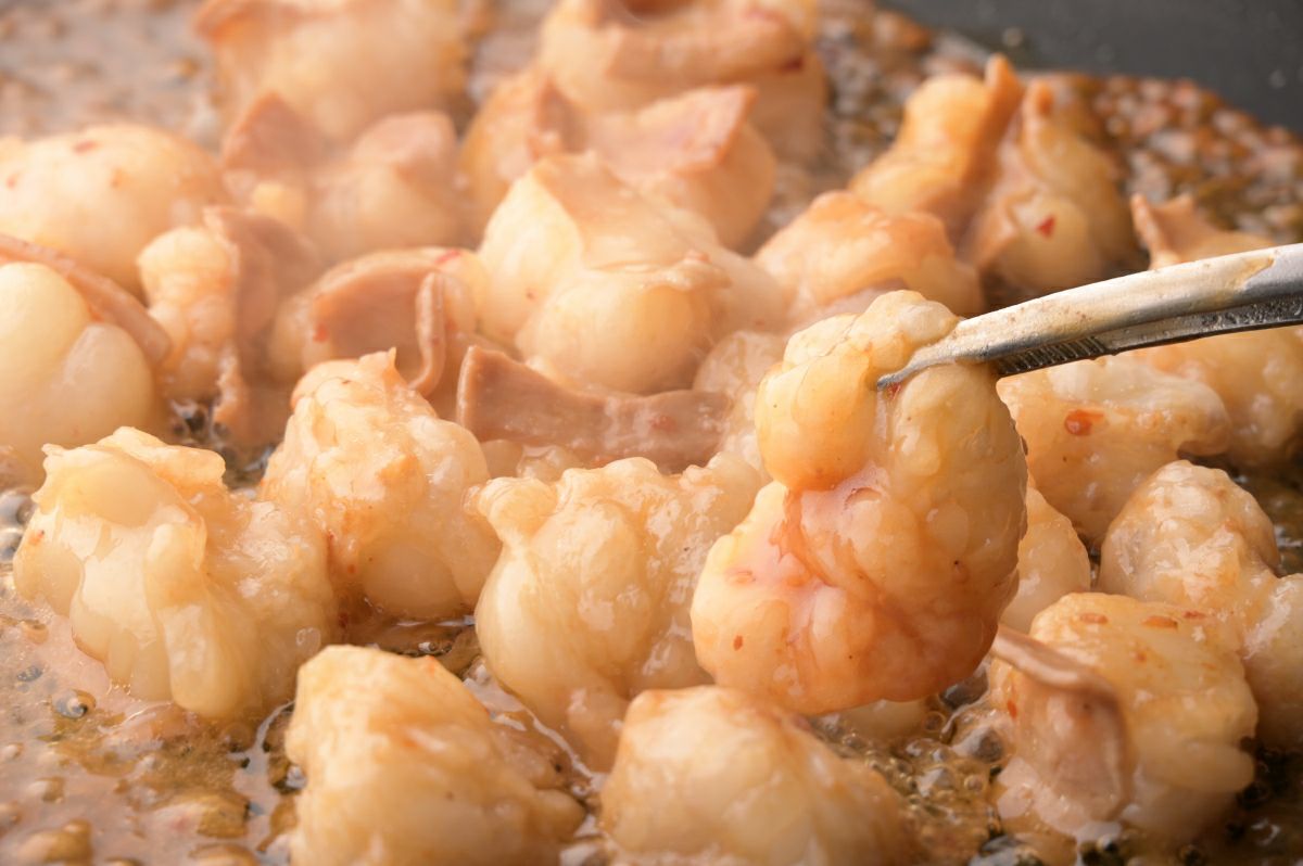 鉄板の上で国産ホルモンを焼いている調理中の画像。ジュージューと焼けるホルモンの食欲をそそる様子が伝わる、焼肉やBBQに最適な大容量セット。