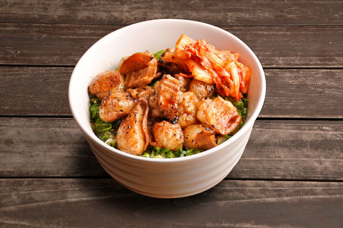 国産ホルモンを調理し、ご飯に盛り付けたホルモン丼の画像。濃厚なタレとホルモンの旨味が絡んだ、ボリューム満点の丼料理。