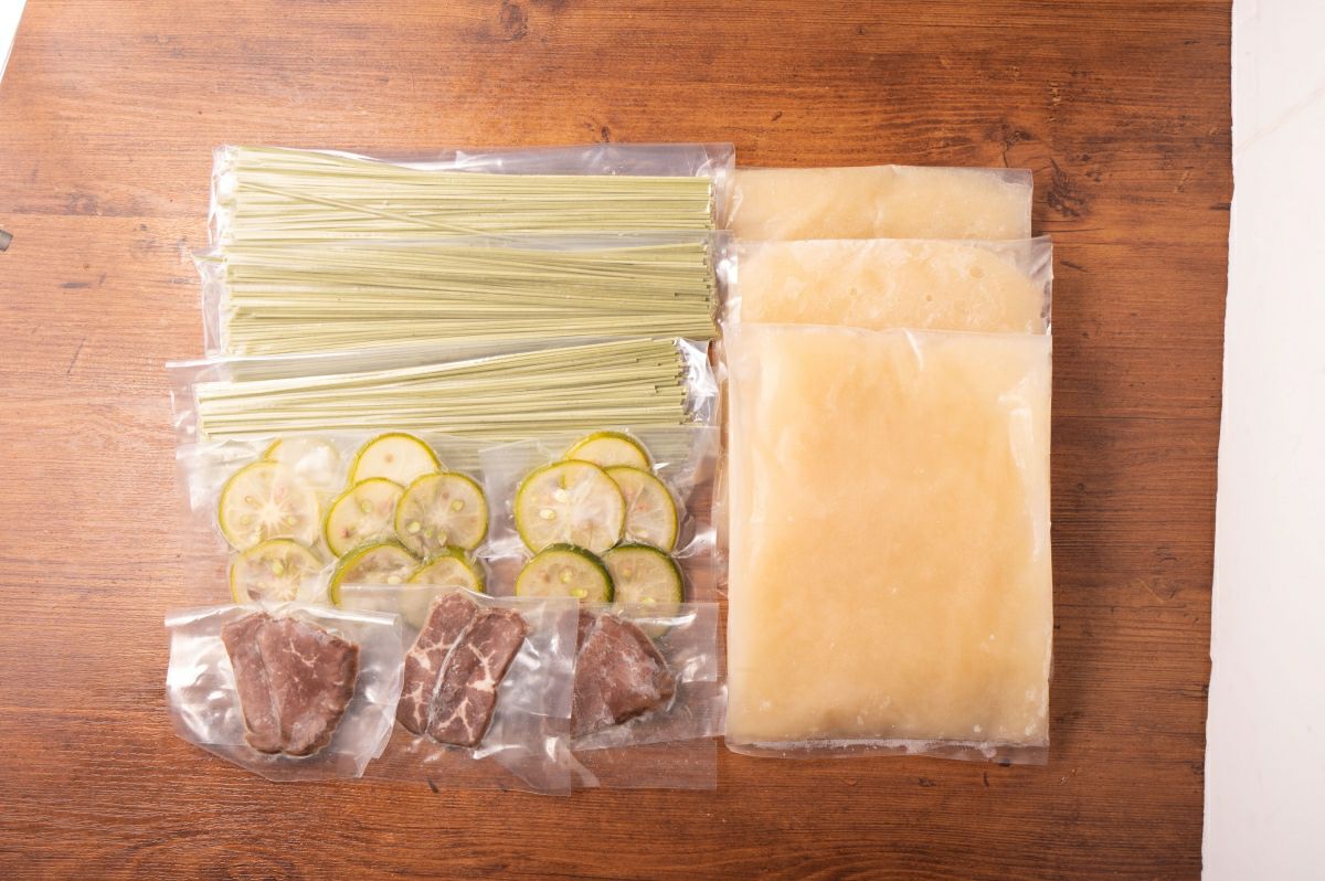 「かぼす冷麺」の麺、スープ、かぼす果汁などが個別にパックに詰められた内容量画像。大分のご当地冷麺を自宅で手軽に楽しめるセット。