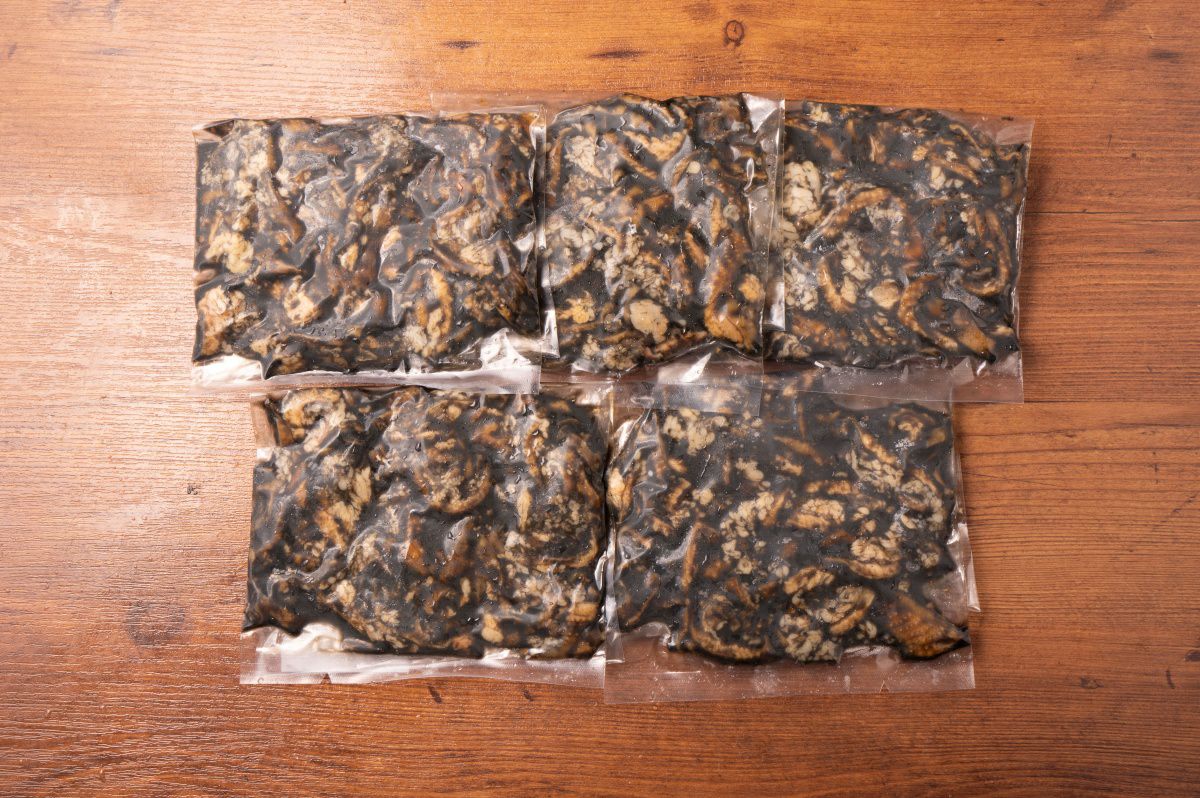 「甘辛鶏皮炭火焼」のレトルトパックが5袋並んだ内容量画像。ご自宅で手軽に専門店の味が楽しめる、大容量のお取り寄せおつまみセット。