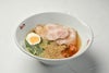 「別府温泉冷麺」の調理後の盛り付け画像。冷たいスープに、コシのある麺、チャーシュー、トマト、ネギ、卵が彩りよく盛り付けられた完成品。