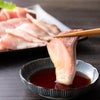 大分県産ブランド魚「かぼすぶり」の切り身を使ったしゃぶしゃぶセットの切り身をそのまま醤油に付けているイメージ画像。冬季限定のかぼすぶりを産地直送でお取り寄せ、通販で鍋料理に。