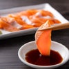 脂がのった桜サーモンのお刺身を醤油につける箸上げ。産地直送ならではの鮮度と、きめ細かなサシが入った身の質感を伝えるアップ写真。